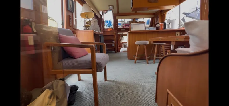 Slide: The Image of Interior of 1988 Offshore Yachts 48 CPMY, featuring cozy seating and wooden furnishings. - 21