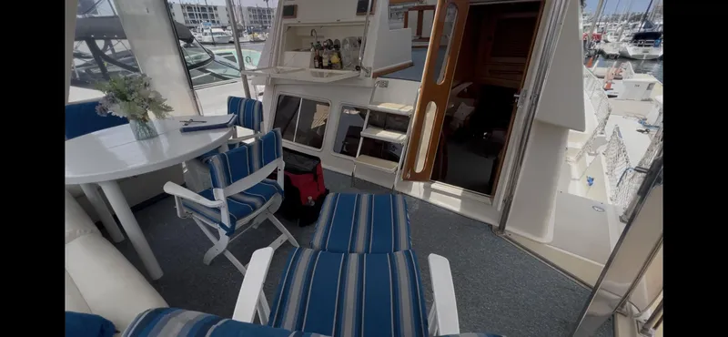 Slide: The Image of Interior of 1988 Offshore Yachts 48 CPMY with striped seating and dining area. - 26