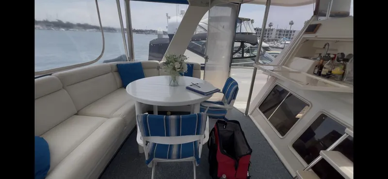 Slide: The Image of Interior of 1988 Offshore Yachts 48 CPMY with seating, table, and marina view. - 27