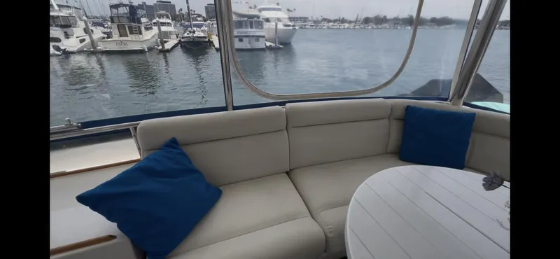 Slide: The Image of Interior view of 1988 Offshore Yachts 48 CPMY with seating and marina backdrop. - 28