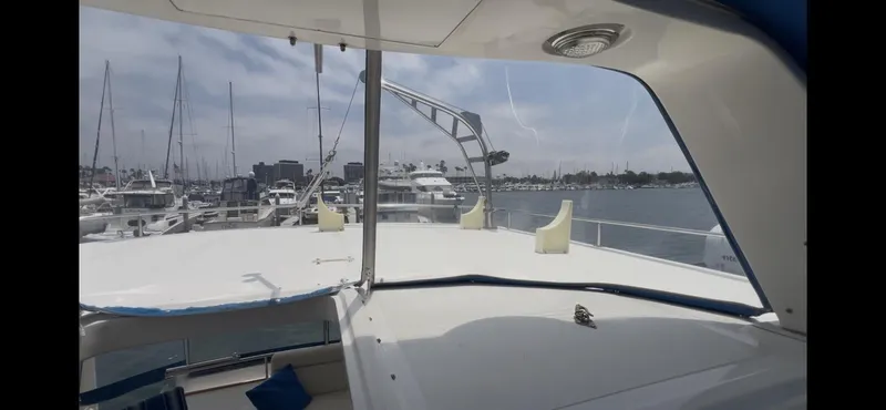 Slide: The Image of 1988 Offshore Yachts 48 CPMY at marina, showcasing spacious deck and scenic harbor view. - 30