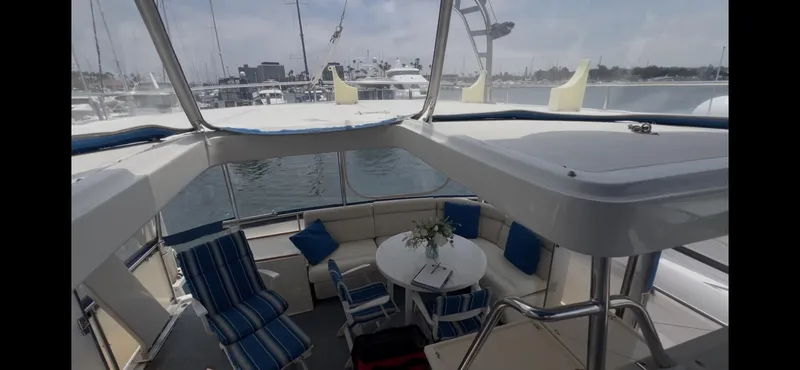 Slide: The Image of 1988 Offshore Yachts 48 CPMY interior with seating and table, docked at marina. - 31