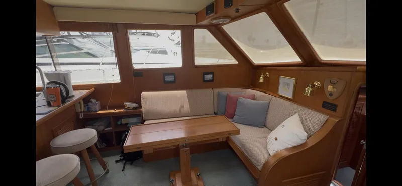 Slide: The Image of 1988 Offshore Yachts 48 CPMY interior with cozy seating and wooden table. - 5