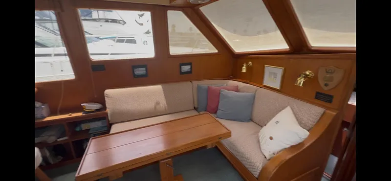 Slide: The Image of Interior of 1988 Offshore Yachts 48 CPMY with cozy seating and wooden table. - 6
