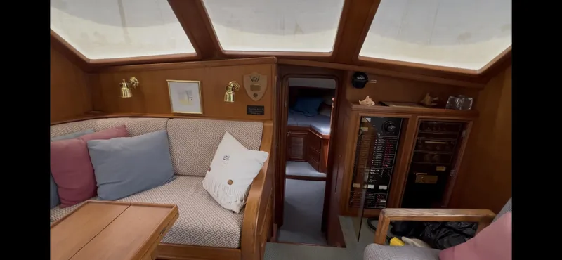 Slide: The Image of Interior of 1988 Offshore Yachts 48 CPMY, featuring cozy seating and wooden cabinetry. - 7