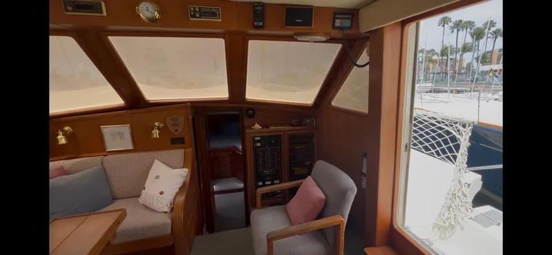 Slide: The Image of Interior of 1988 Offshore Yachts 48 CPMY, featuring cozy seating and large windows. - 9