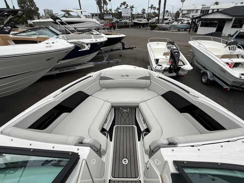 Slide: The Image of 2024 Sea Ray SLX 260 boat interior with luxurious seating, displayed at a marina. - 14