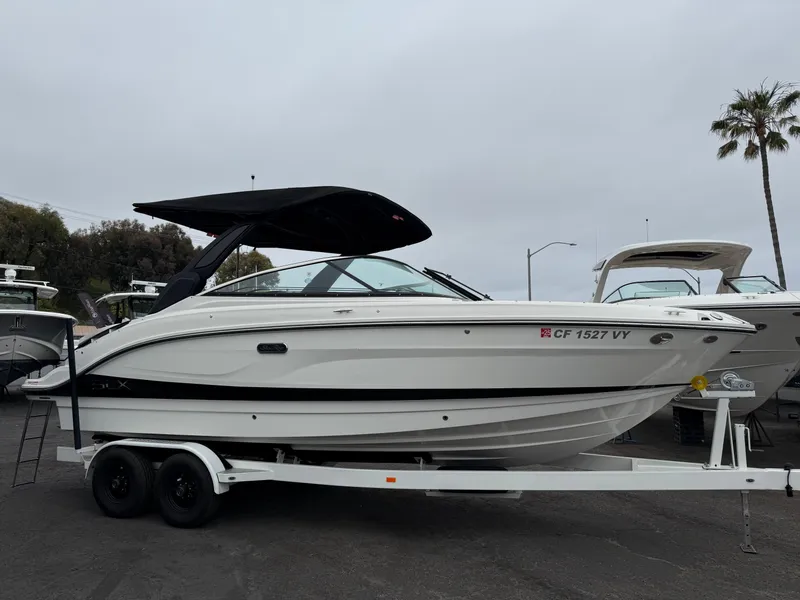 Slide: The Image of 2024 Sea Ray SLX 260 boat on trailer, featuring sleek design and black canopy. - 2