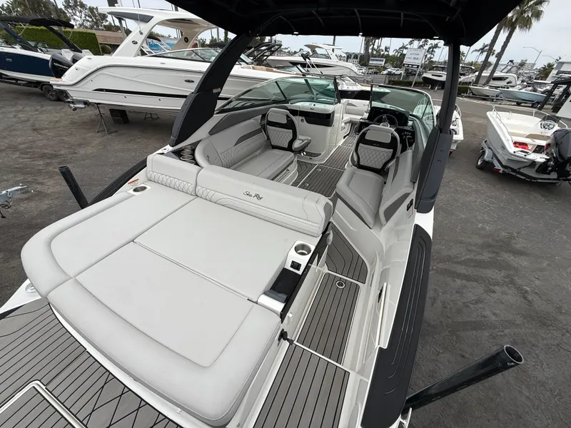 Slide: The Image of 2024 Sea Ray SLX 260 boat with spacious seating and sleek design at a marina. - 6