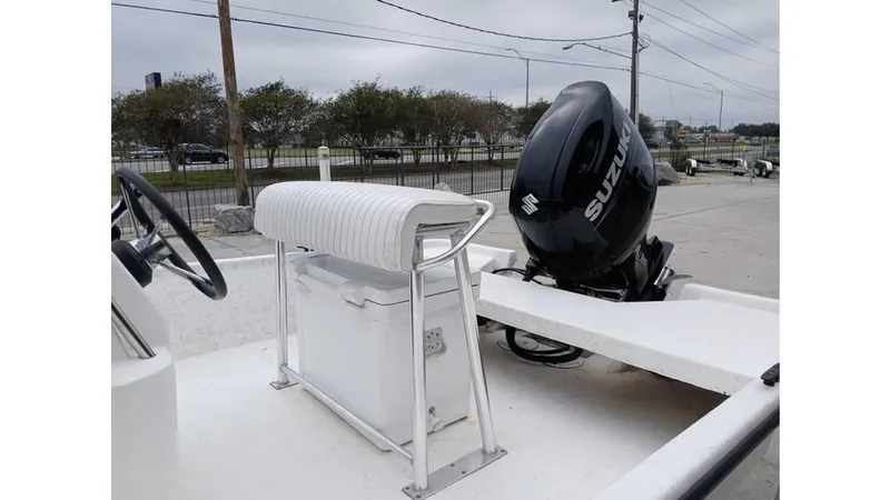 Slide: The Image of 2006 Mako 211 boat with Suzuki outboard motor, white seating, and steering wheel. - 6