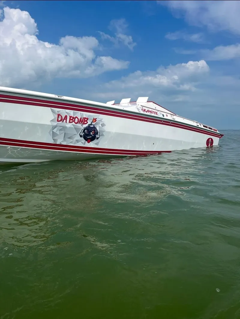 Slide: The Image of 1987 Cigarette 38 Top Gun speedboat on water, featuring "DA BOMB" graphic, under blue sky. - 2