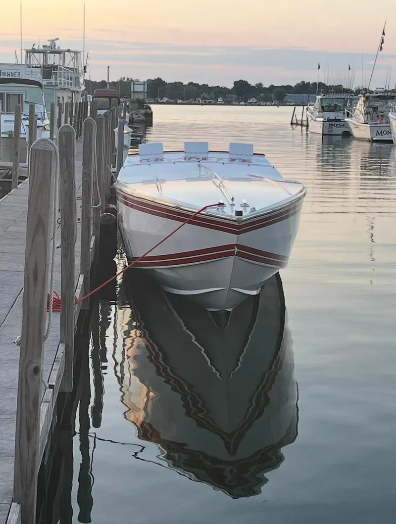 Slide: The Image of 1987 Cigarette 38 Top Gun boat docked at serene marina during sunset. - 9