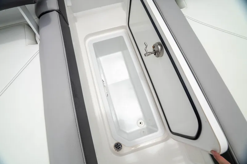 Slide: The Image of 2023 Cobalt R6 Outboard boat storage compartment with open lid and sleek design. - 14