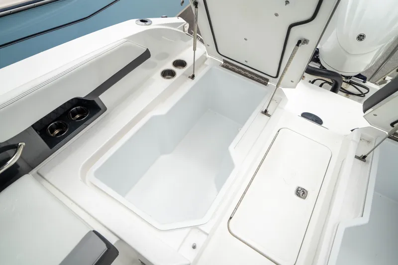 Slide: The Image of 2023 Cobalt R6 Outboard boat interior with open storage compartments and cup holders. - 18