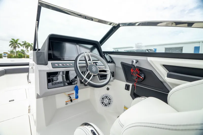 Slide: The Image of 2023 Cobalt R6 Outboard boat cockpit with modern steering and dashboard controls. - 2