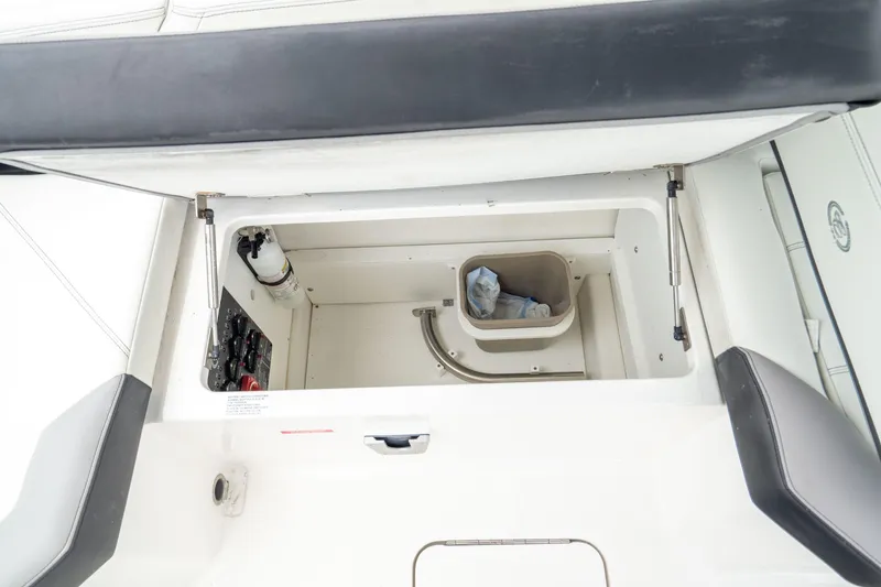Slide: The Image of 2023 Cobalt R6 Outboard storage compartment with open lid and visible interior components. - 26