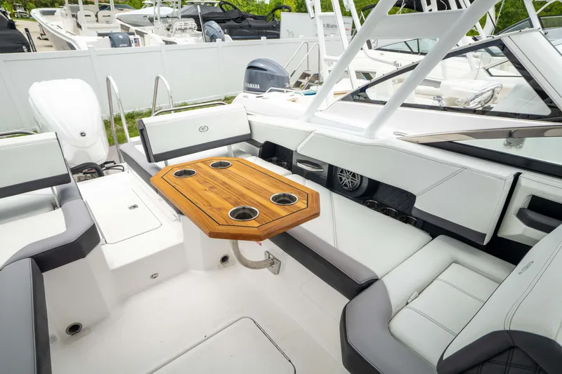 Slide: The Image of 2023 Cobalt R6 Outboard boat interior with wooden table and seating. - 4