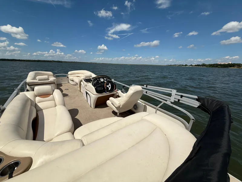 Slide: The Image of 2011 Sun Tracker Regency Party Barge 22 on a lake, featuring spacious seating and clear skies. - 28