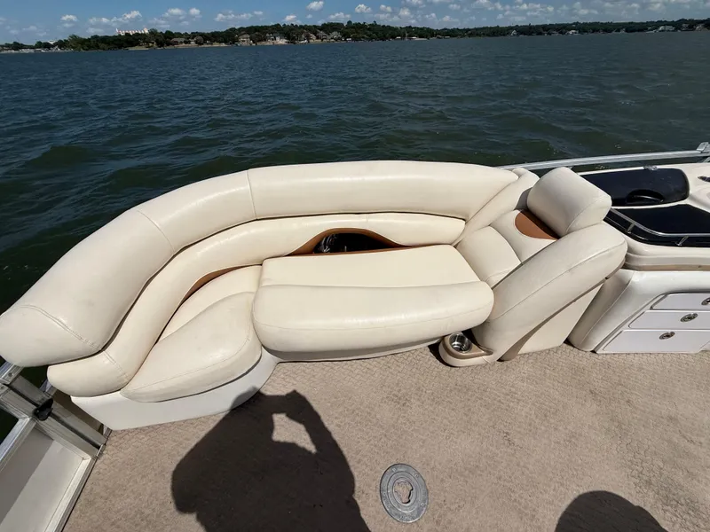 Slide: The Image of 2011 Sun Tracker Regency Party Barge 22 with white cushioned seating on a lake. - 33