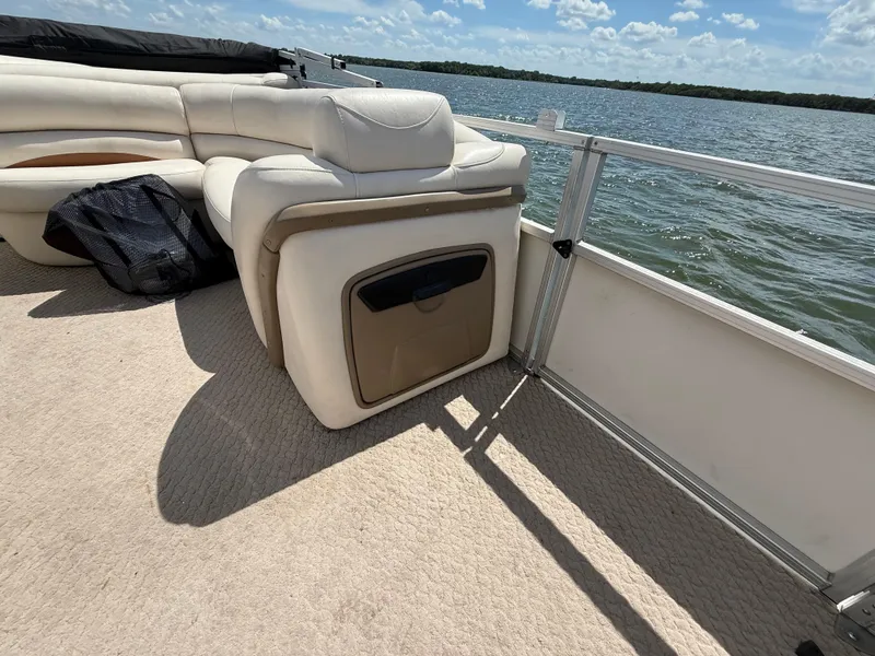 Slide: The Image of 2011 Sun Tracker Regency Party Barge 22 with beige seating on a lake. - 34