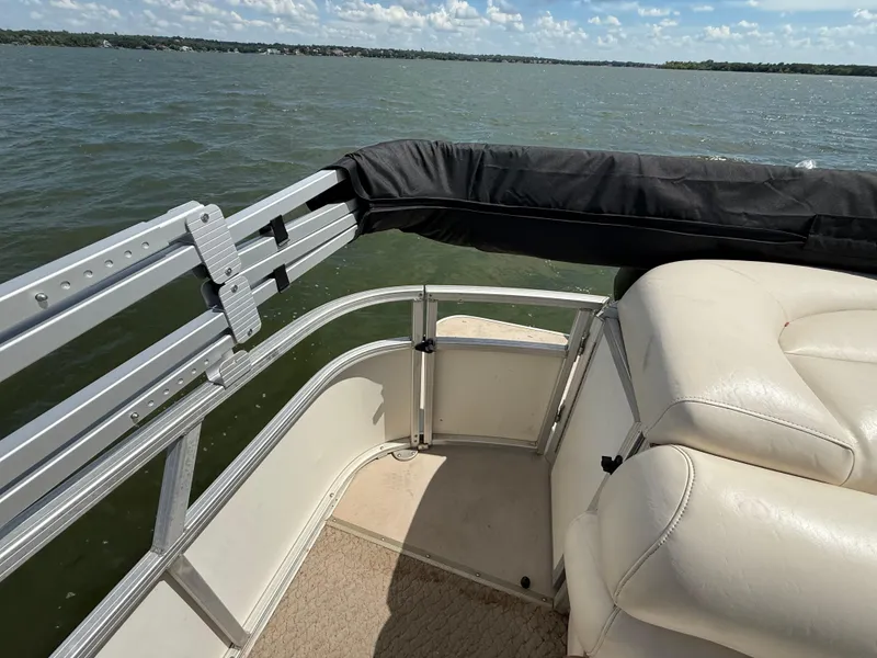 Slide: The Image of 2011 Sun Tracker Regency Party Barge 22 with white cushioned seating on a lake. - 48