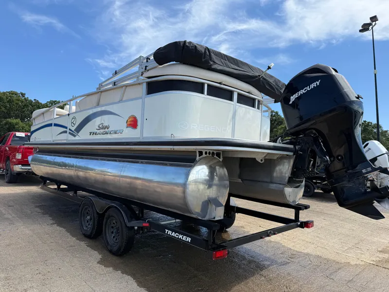 Slide: The Image of 2011 Sun Tracker Regency Party Barge 22 on trailer by a lake under blue sky. - 9