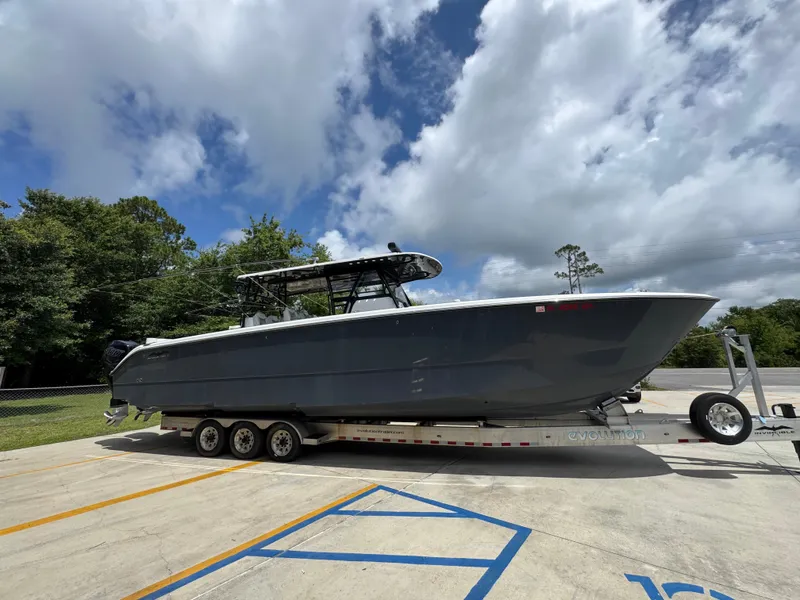 Slide: The Image of 2020 Invincible 40 Catamaran on trailer under cloudy sky. - 10