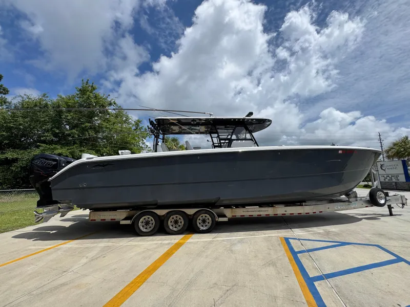 Slide: The Image of 2020 Invincible 40 Catamaran on trailer, parked outdoors under cloudy sky. - 11