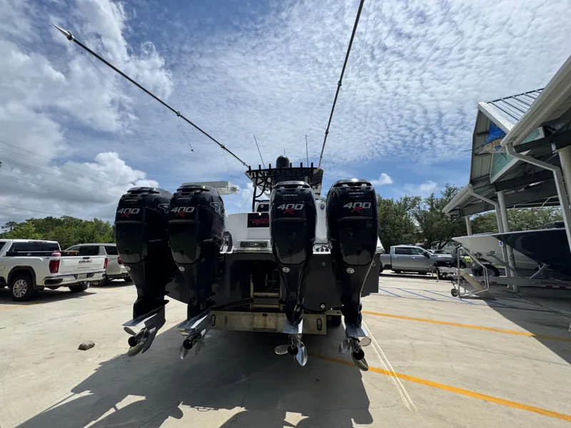 Slide: The Image of 2020 Invincible 40 Catamaran with four powerful outboard engines, parked outdoors under a cloudy sky. - 14