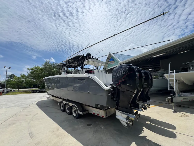 Slide: The Image of 2020 Invincible 40 Catamaran with triple engines on a trailer under a cloudy sky. - 16