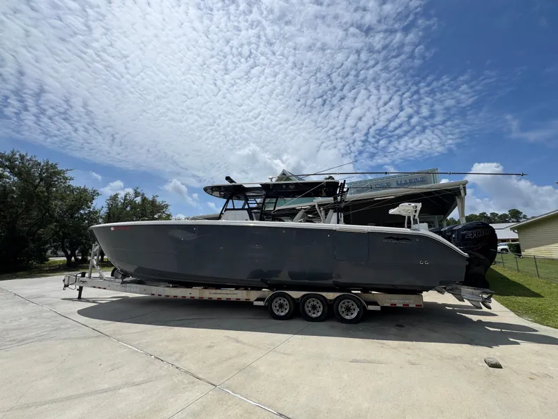 Slide: The Image of 2020 Invincible 40 Catamaran on trailer under a partly cloudy sky. - 18