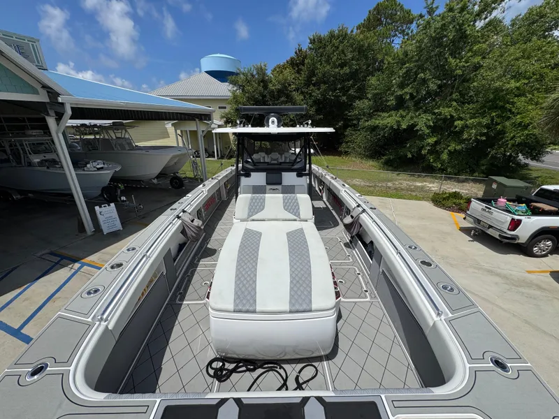 Slide: The Image of 2020 Invincible 40 Catamaran docked, showcasing spacious deck and sleek design under clear skies. - 24