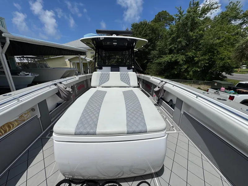 Slide: The Image of Invincible 40 Catamaran 2020 with spacious deck and cushioned seating under clear blue sky. - 25