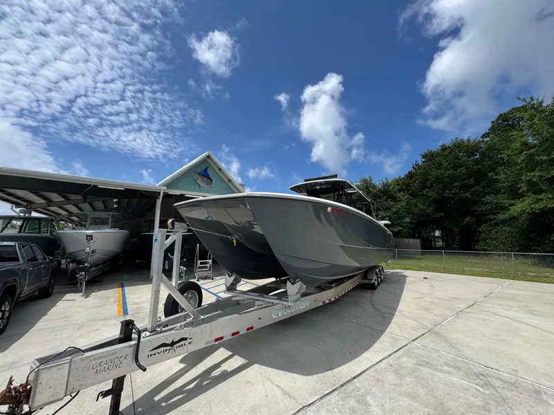 Slide: The Image of 2020 Invincible 40 Catamaran on trailer under blue sky, parked outdoors. - 4