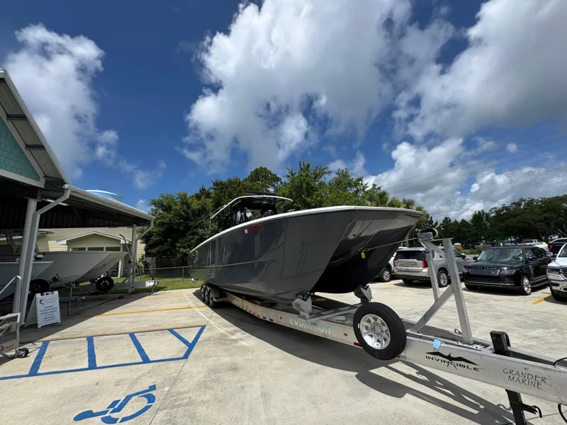 Slide: The Image of 2020 Invincible 40 Catamaran on trailer, parked outdoors under a partly cloudy sky. - 8
