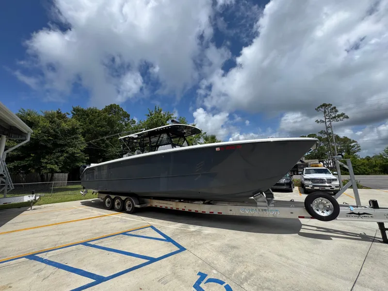 Slide: The Image of 2020 Invincible 40 Catamaran on trailer, parked outdoors under a partly cloudy sky. - 9