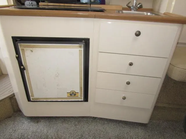 Slide: The Image of 1999 Maxum 2800SCR boat kitchenette with fridge, drawers, and sink. - 12