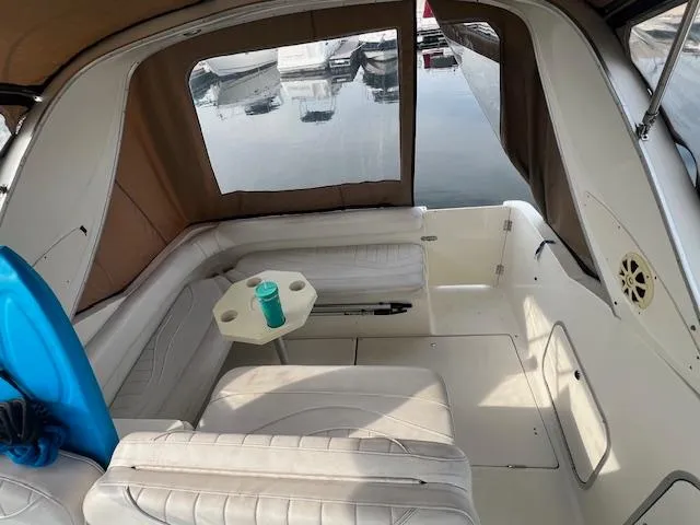 Slide: The Image of Interior of 1999 Maxum 2800SCR boat with seating and table, docked at marina. - 4