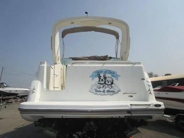 Slide: The Image of 1999 Maxum 2800SCR boat, rear view, with custom graphic on transom, parked on trailer. - 7