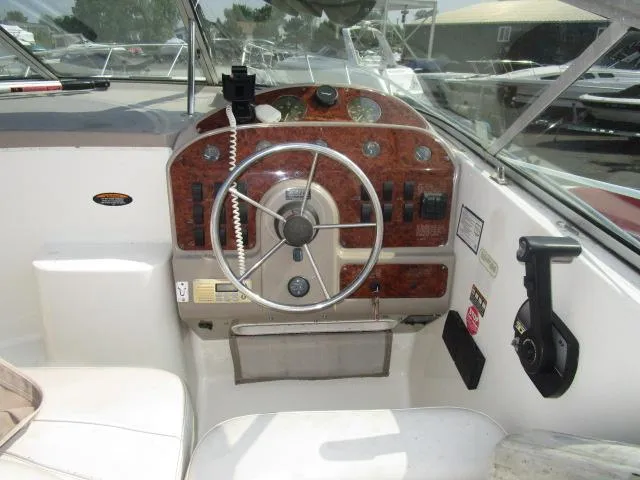Slide: The Image of 1999 Maxum 2800SCR boat cockpit with steering wheel and control panel. - 8