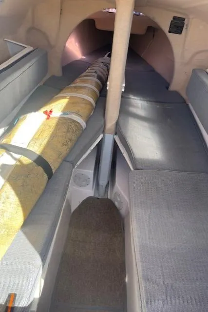 Slide: The Image of Interior of a 2012 Corsair Dash 750 sailboat, featuring compact seating and a stored mast. - 4