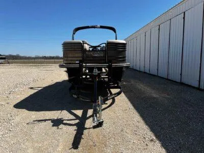 Slide: The Image of 2025 SunCatcher Elite 324 SS boat on trailer, parked outdoors near a white building. - 3