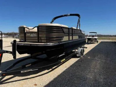 Slide: The Image of 2025 SunCatcher Elite 324 SS pontoon boat on trailer, parked outdoors. - 4