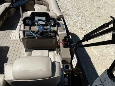 Slide: The Image of 2025 SunCatcher Elite 324 SS boat interior with steering console and beige seating. - 9