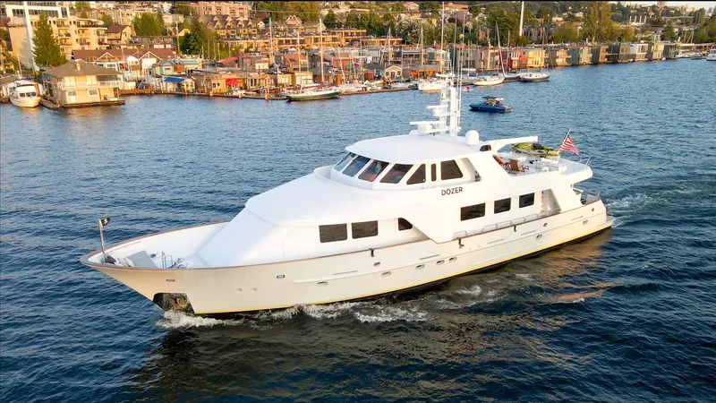 The Image of Luxurious 1993 Queenship LRC yacht cruising near a scenic waterfront community. - 0