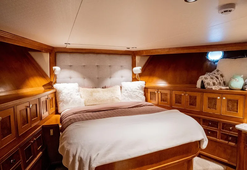 Slide: The Image of Luxurious 1993 Queenship LRC yacht bedroom with wood paneling and plush bedding. - 12
