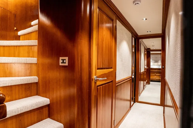 Slide: The Image of Luxurious wooden interior of a 1993 Queenship LRC yacht, featuring a hallway and staircase. - 16