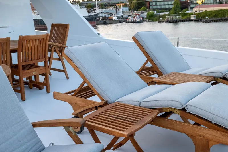 Slide: The Image of Luxury yacht deck with wooden lounge chairs and table, Queenship LRC 1993, waterfront view. - 21