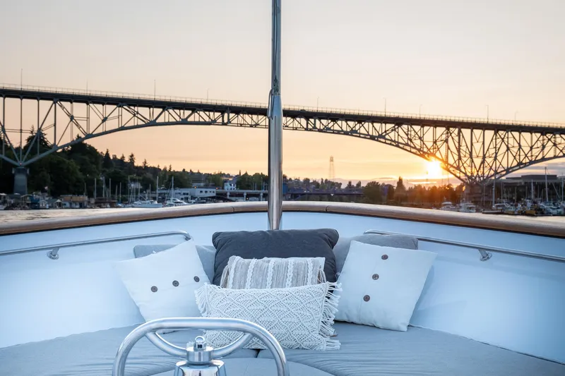 Slide: The Image of 1993 Queenship LRC yacht with cushions, bridge view, and sunset in the background. - 22