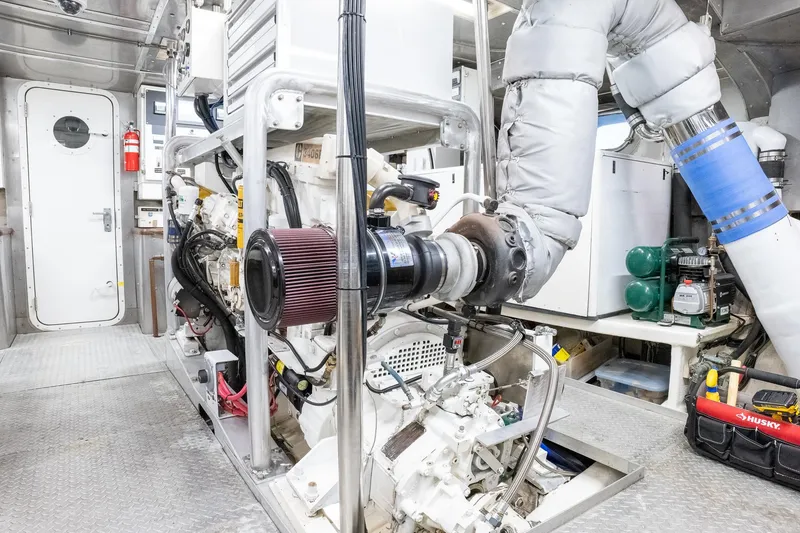 Slide: The Image of Engine room of a 1993 Queenship LRC yacht, featuring machinery and equipment. - 26